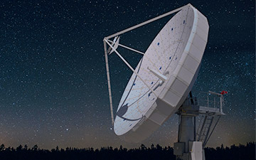 White ground satellite antenna against a starry night sky