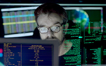 Man wearing glasses looking at projected computer data