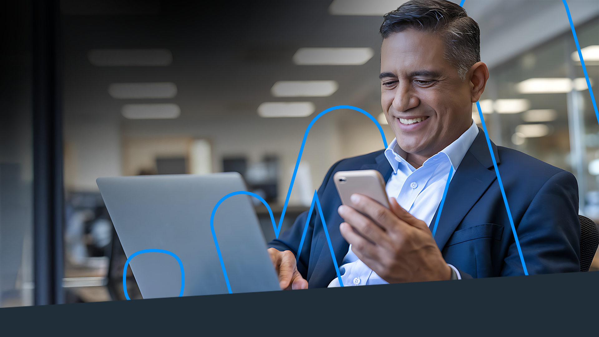 Homem mexendo no laptop e no celular