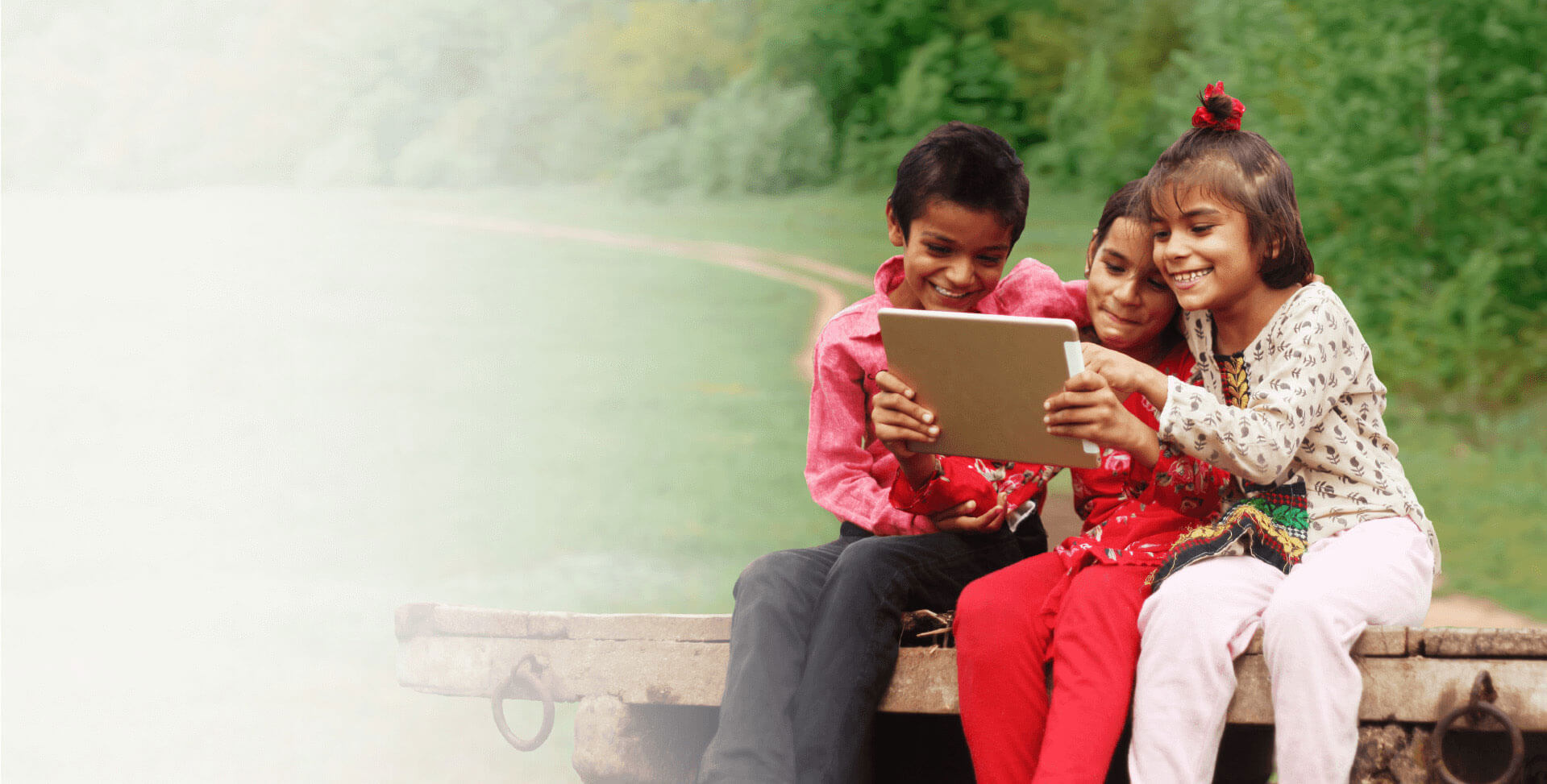Niños sonrientes en el campo usando una tablet 