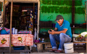 Un hombre sonriente usando un smartphone con internet comunitario