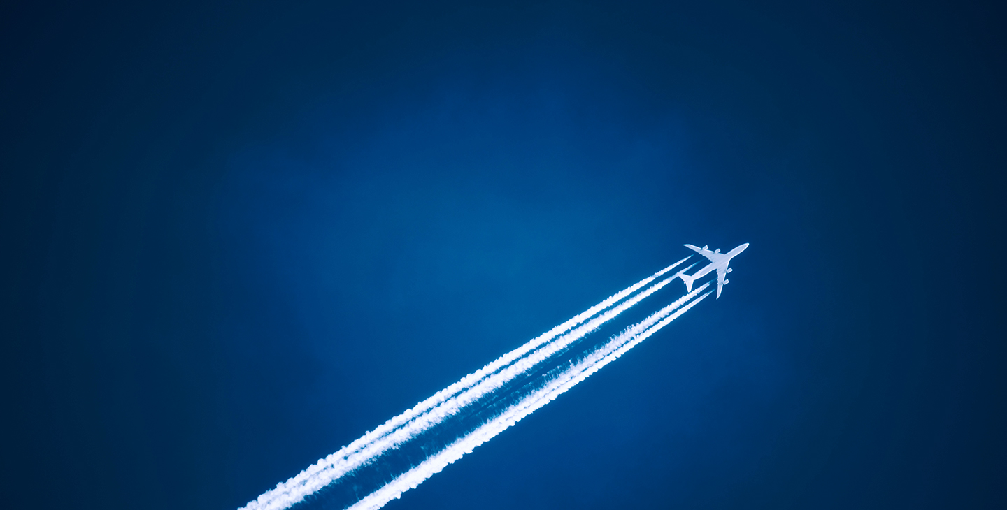 White airplane with airplane internet flying through the sky against a dark blue background