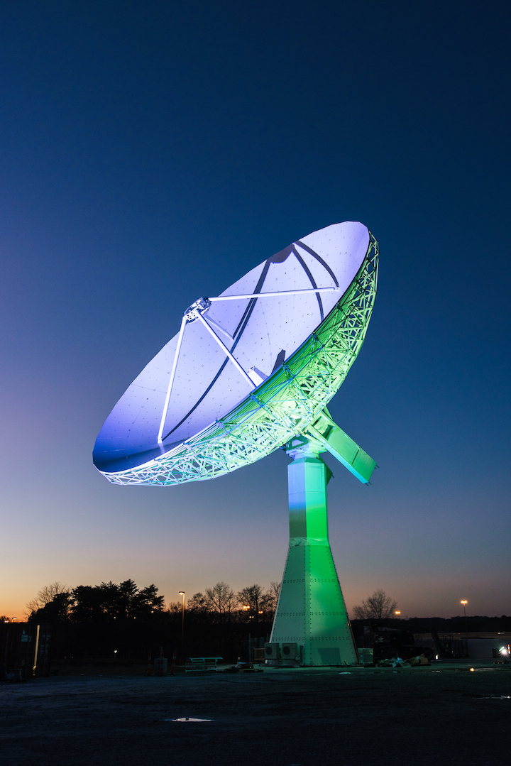 large antenna lit with green and blue at night