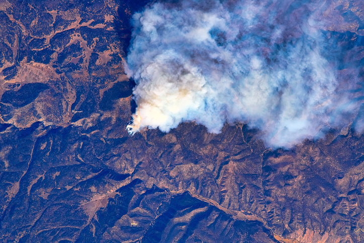An aerial view of wildfires raging across the mountains