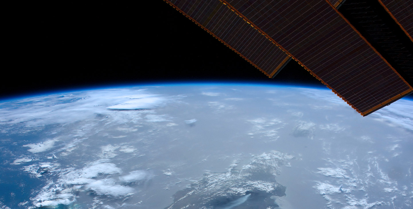 Edges of the solar array of a Viasat satellite in space orbiting around the Earth