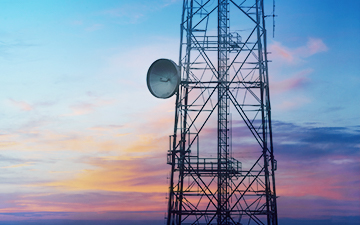 Celluar and satellite internet tower in front of a colorful sunset
