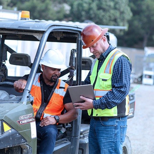 2 construction workers discussion information on a tablet connected with business satellite internet
