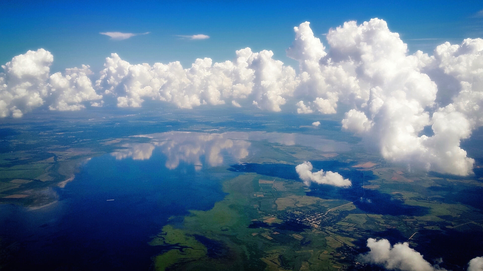 Aerial view of clouds, lake and small town