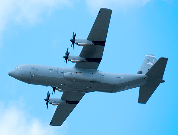 Bottom-view of a military plane in-flight against a blue sky