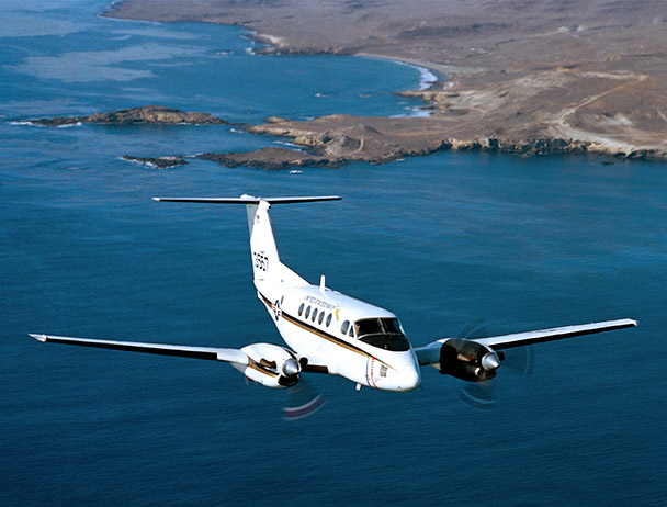 Private VIP jet flying above a coastline