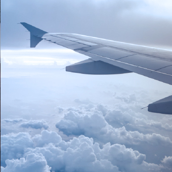 Close-up of the left wing of an airplane flying above the clouds