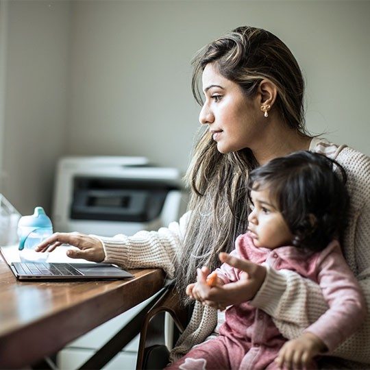 A mother and child working on a laptop connected by Viasat satellite internet