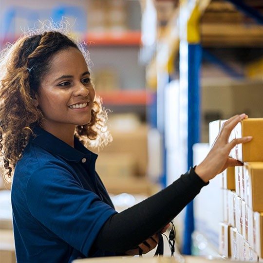 A female warehouse worker stocking a shelf