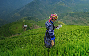 A woman in the remote central american hills using Viasat satellite internet on a tablet