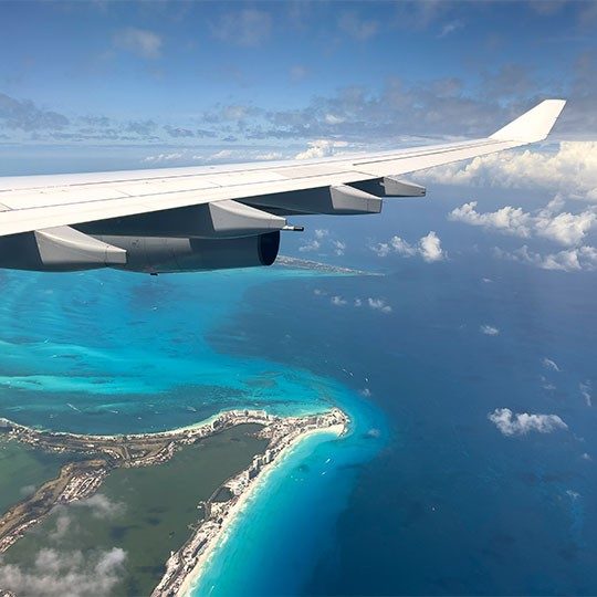 A commercial jet flying over the ocean, connected by Viasat satellite internet