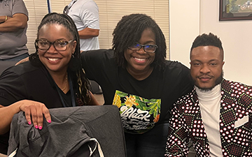 Black Viasat employee at table during STEM event