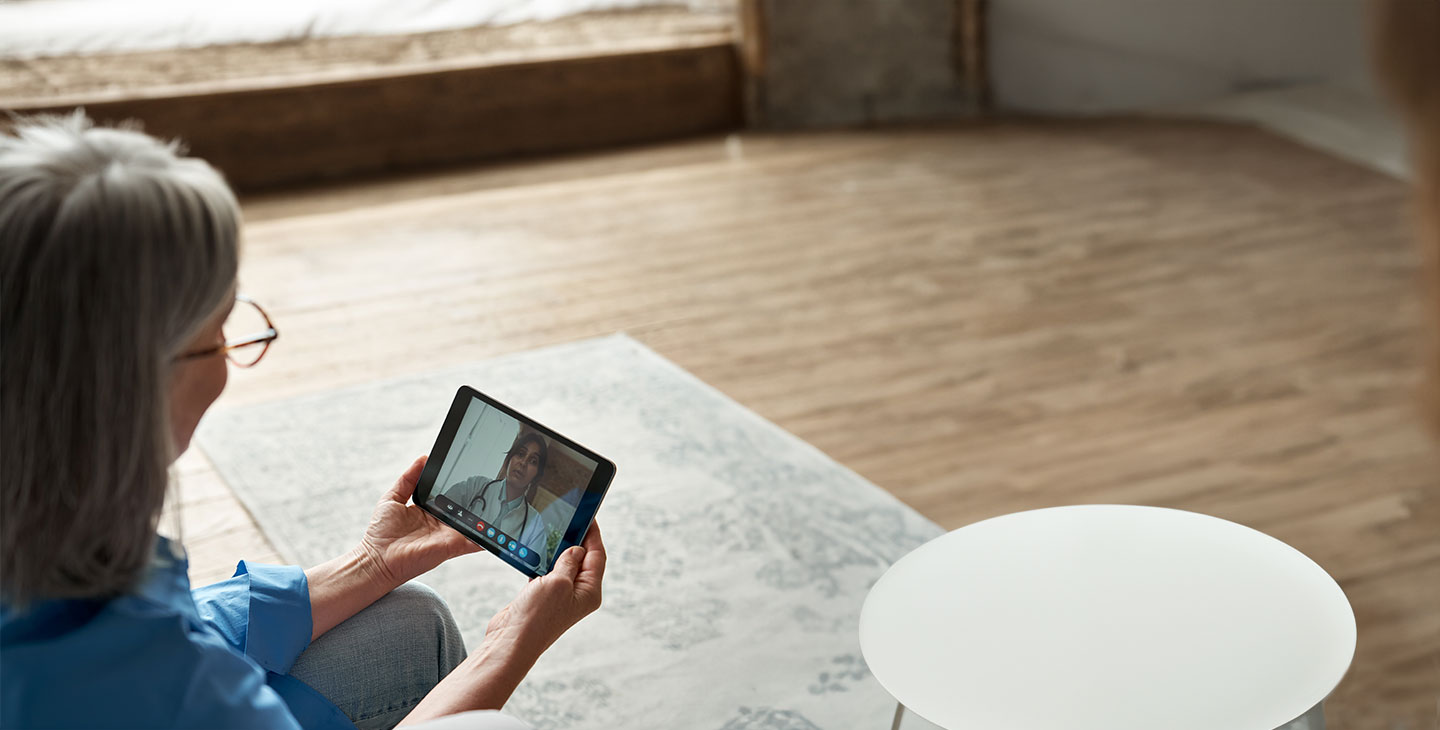 a woman using a tablet for a telehealth appointment, connected by Viasat satellite internet