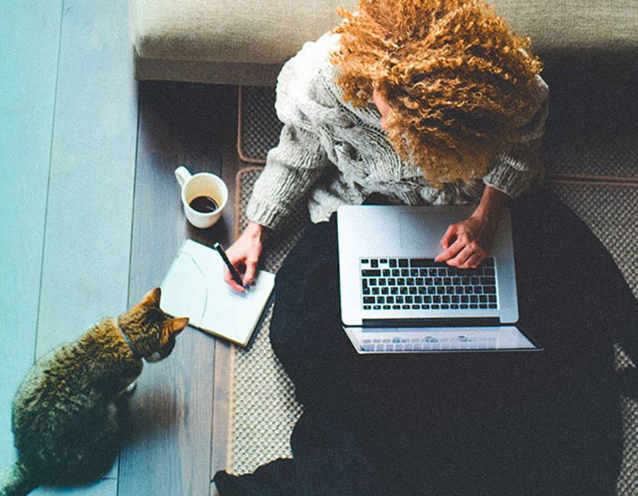 A girl at home, working on her laptop connected by Viasat satellite internet