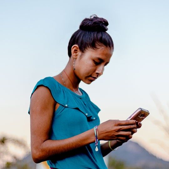 young woman connecting through community internet on mobile