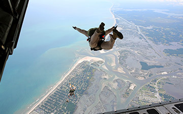 Warfighters with parachutes jumping out the back of a C-17 aircraft 