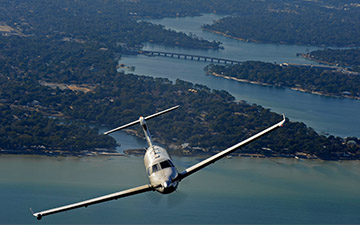 Top view of an aircraft flying over a body of water
