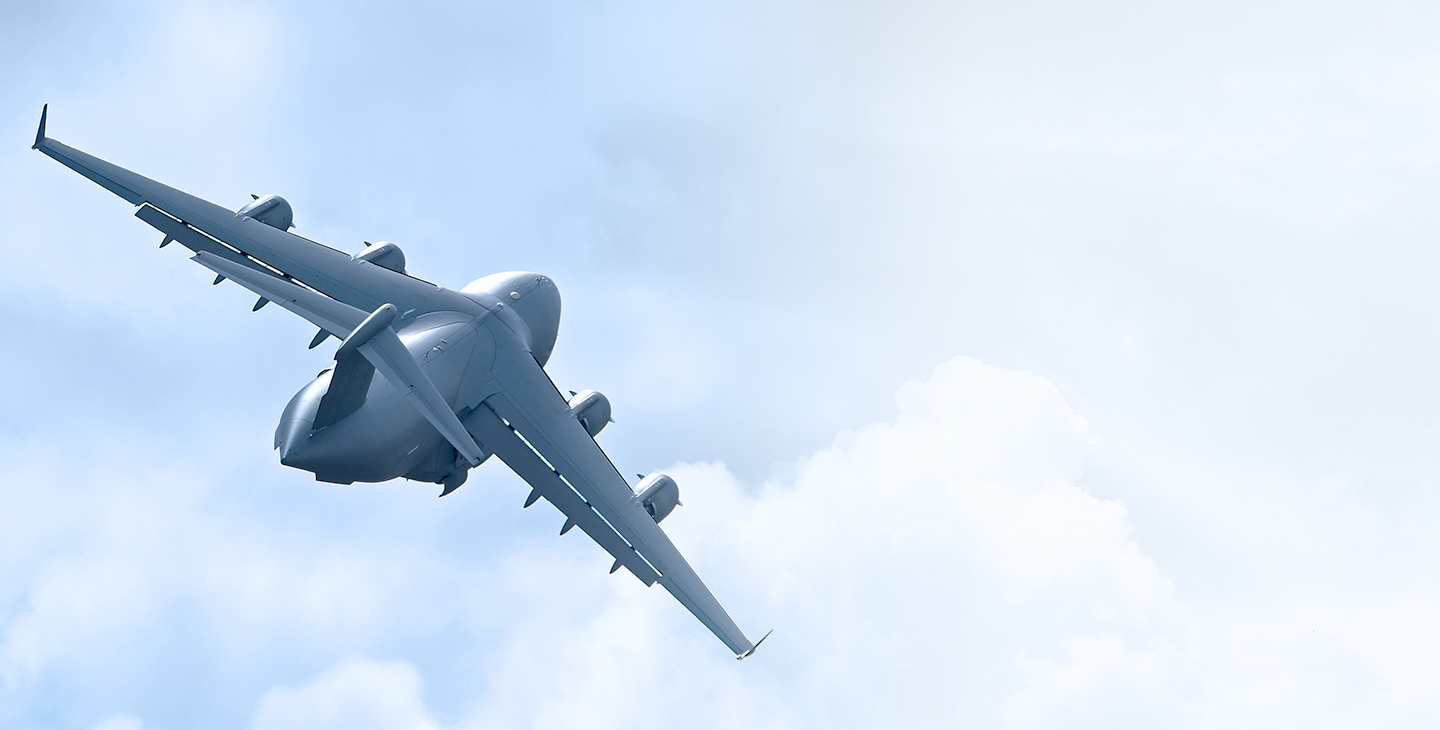 A C-17 aircraft taking off into the clouds