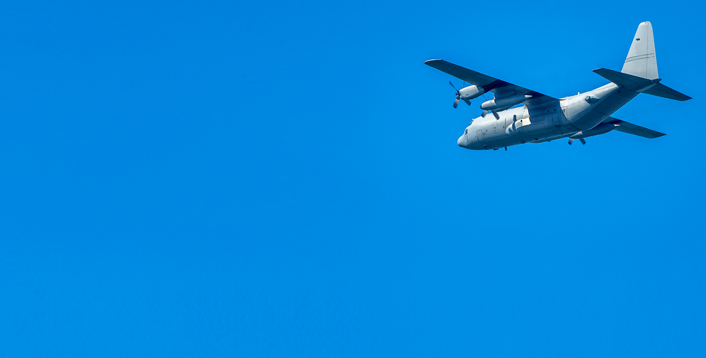 Aircraft flying against a bright blue sky, utilizing dual-band antennas for airborne communications