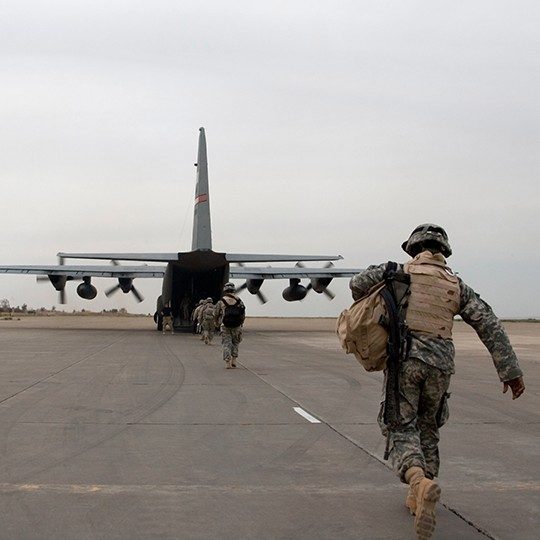 Warfighters with gear loading onto the back of a C-17 aircraft equipped with airborne technology