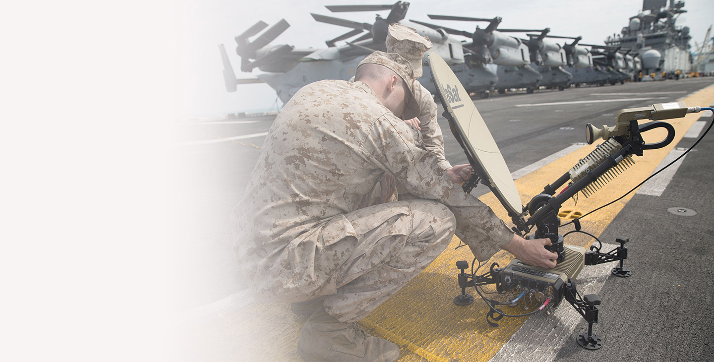 Two warfighters setting up Viasat's Multi-Mission ground terminal on an aircraft carrier