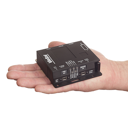 Top/side view of a right hand holding a black, KG-250XS Inline Network Encryptor with the Viasat logo in white