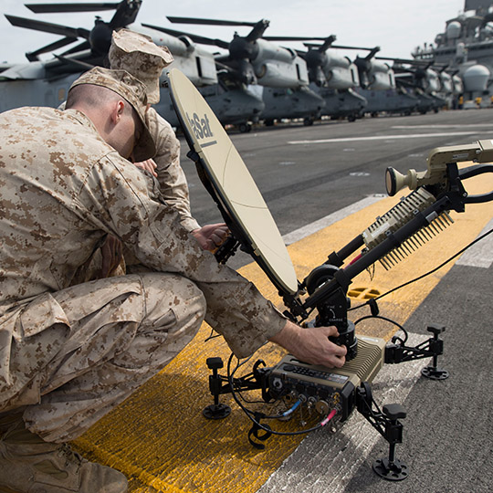 Two soldiers setting up a satellite terminal