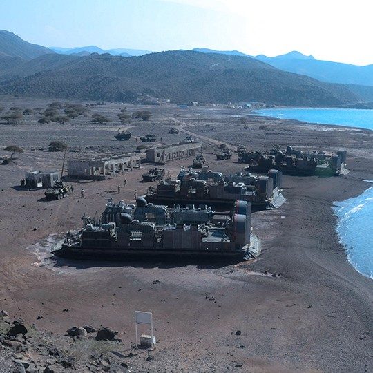Military base with expeditionary vehicles utilizing defense communications