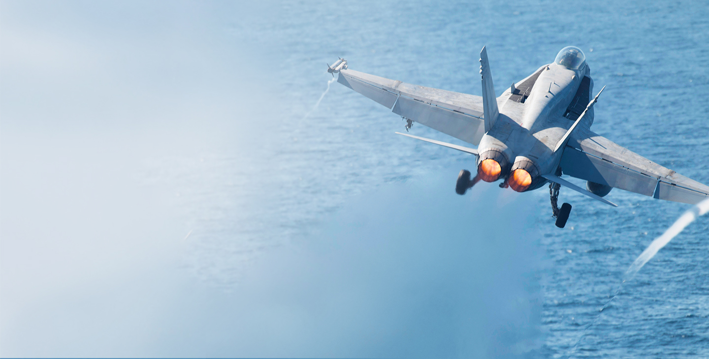 Military jet flying over the ocean