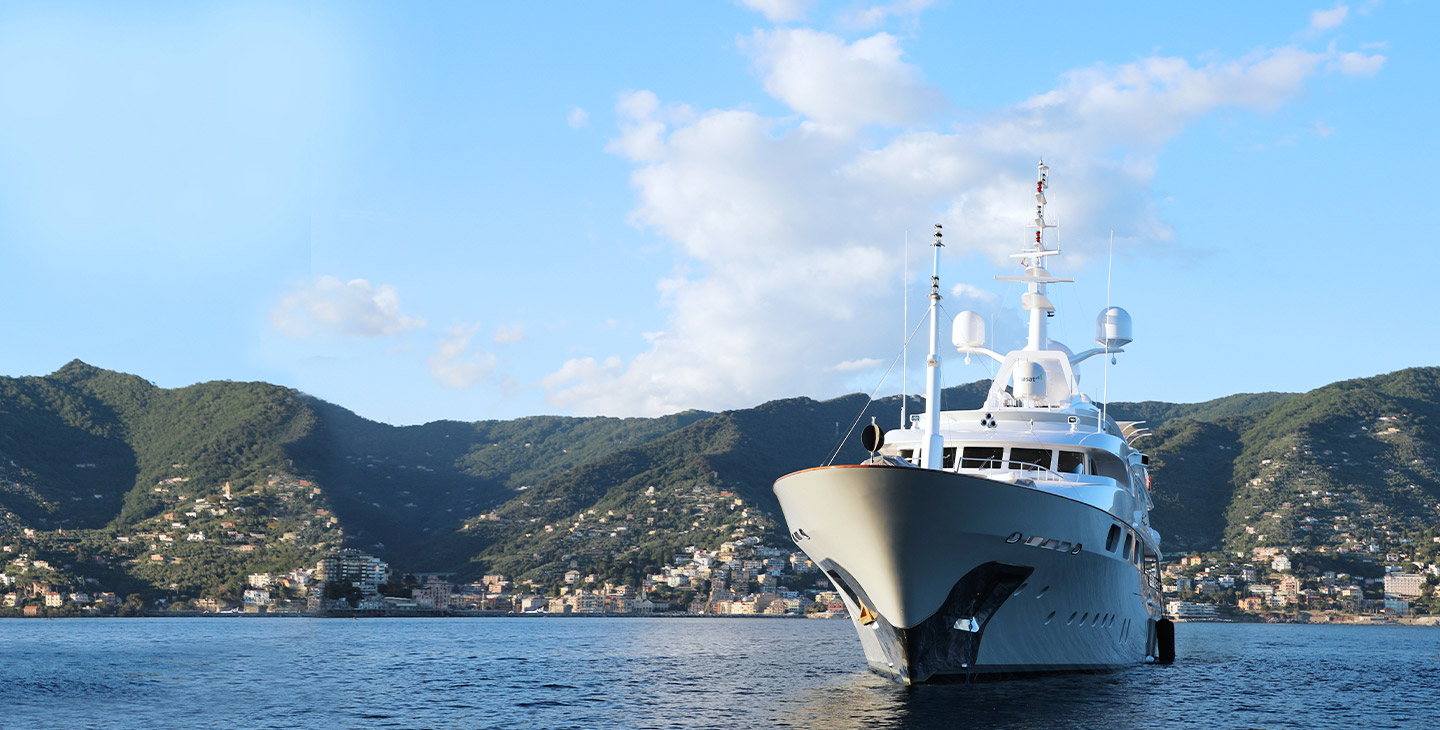 Yacht in a bay connected with marine satellite internet with Viasat's Cobham sailor antenna.