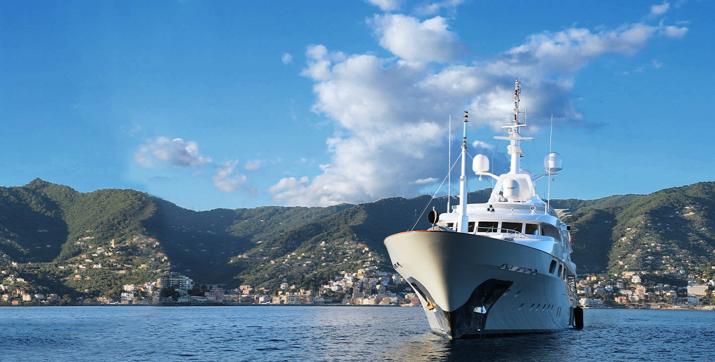 Yacht in a bay connected with marine satellite internet with Viasat's Cobham sailor antenna.