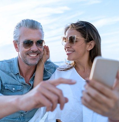 A man and woman using internet for yachts, video chatting on a smart phone