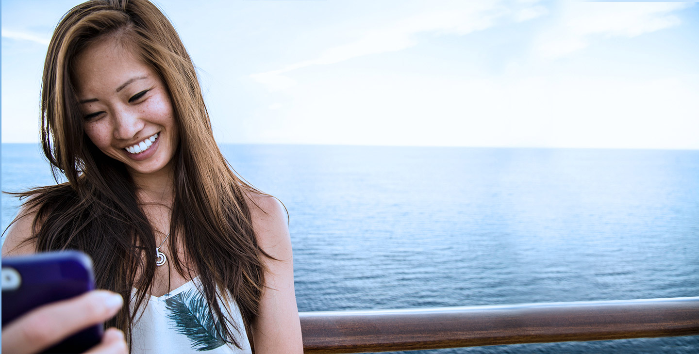Woman on the deck of a boat at sea, video chatting with high speed internet at sea