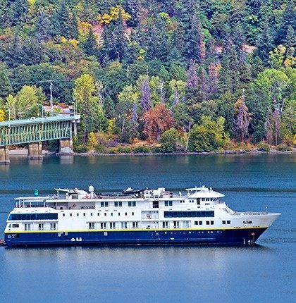 Boat with maritime access system installed, passing in front of a bridge and fall trees