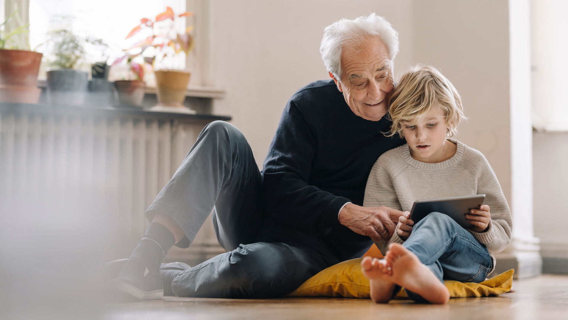 Grandpa and boy browsing web on tablet with Viasat Shield internet security protection