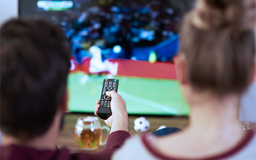 A couple watching sports on TV over internet with their home internet bundle