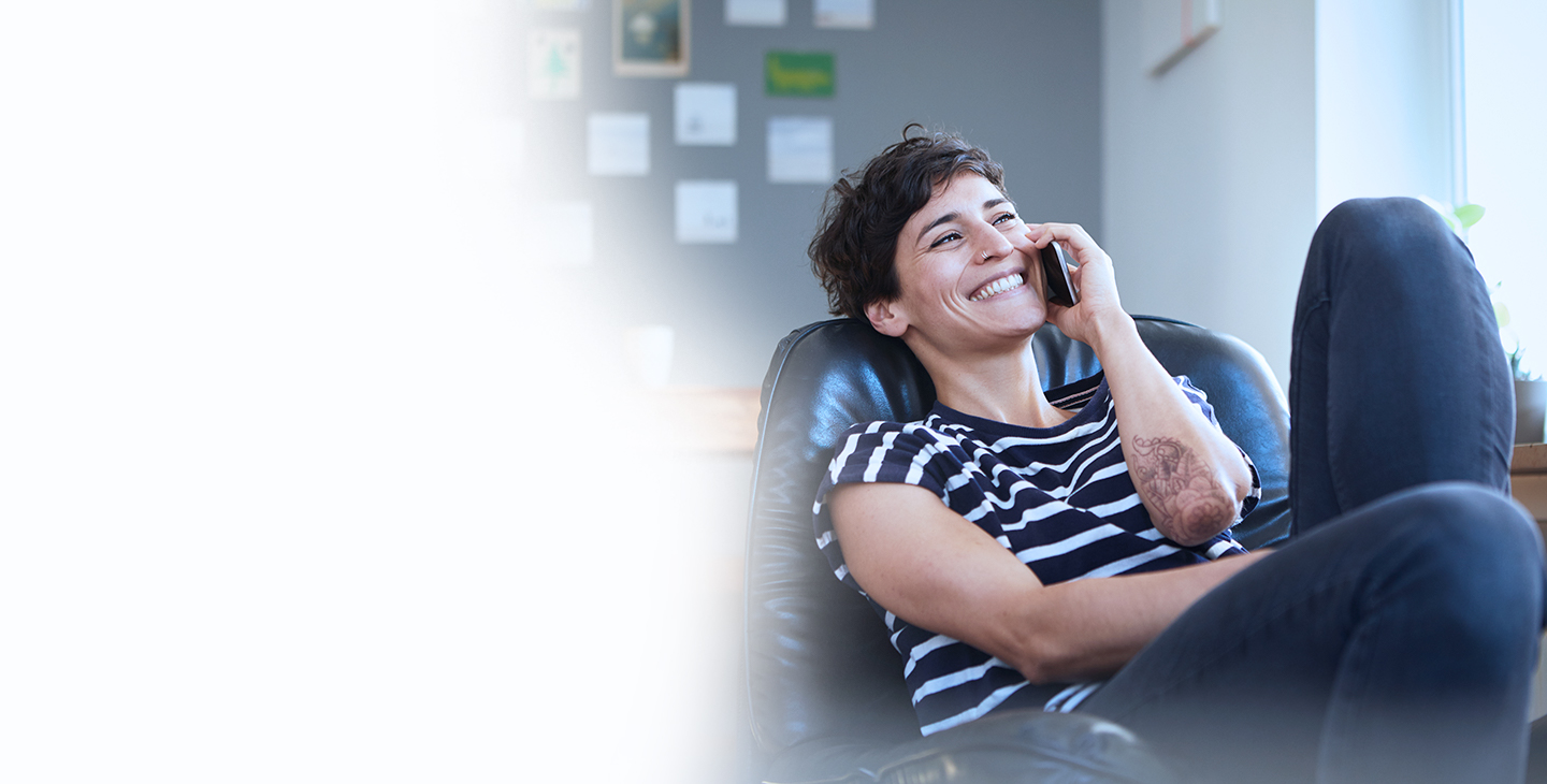 A woman with short dark hair and a striped shirt using VoIP home phone service