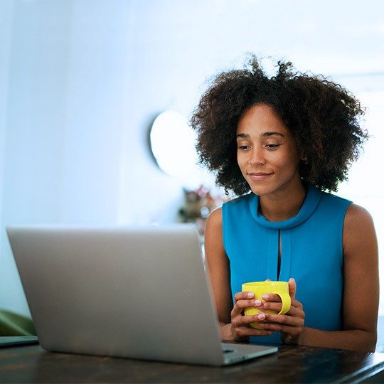 Woman on laptop adding the ACP discount to her Viasat home satellite internet plan