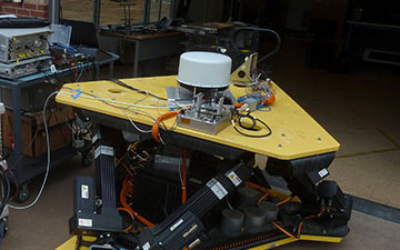 Image of a yellow and grey antenna component being tested in a lab