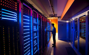 A man standing in a glowing server room