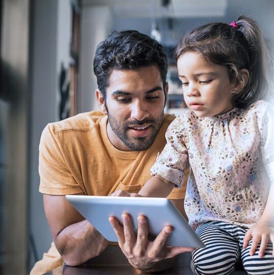 Man and a child using Wi-Fi on a tablet