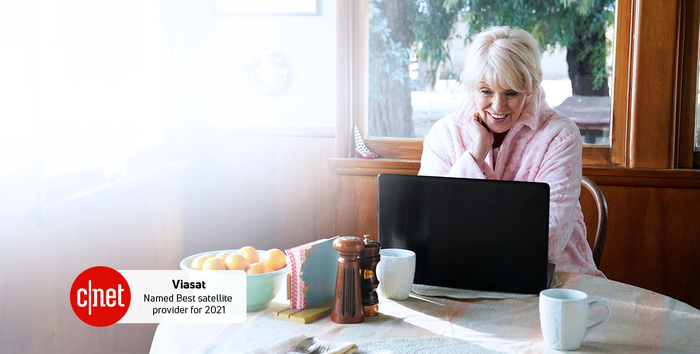Woman enjoying connecting with her family on her laptop with Viasat satellite home internet