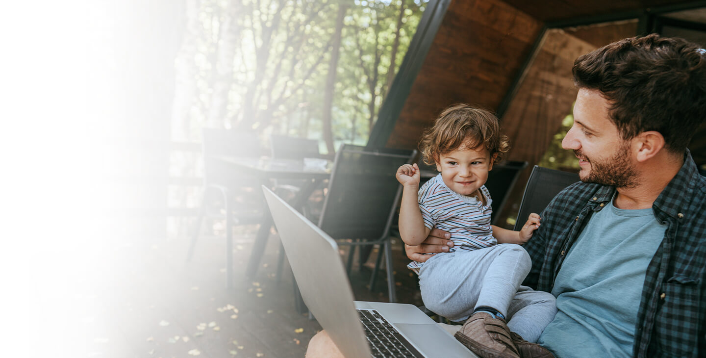 Man and a child outside enjoying access to Viasat home satellite Internet on a laptop