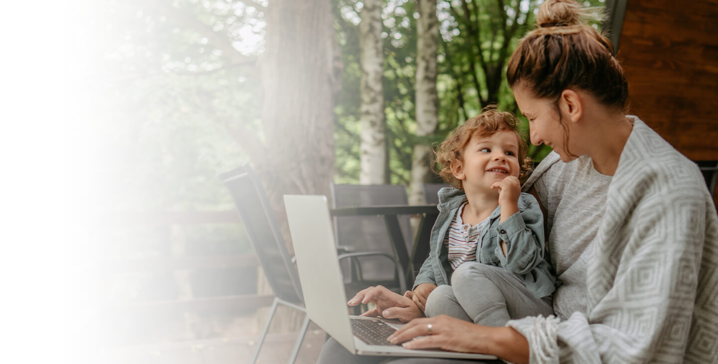 Mother and child enjoying satellite internet from the deck of their rural home.