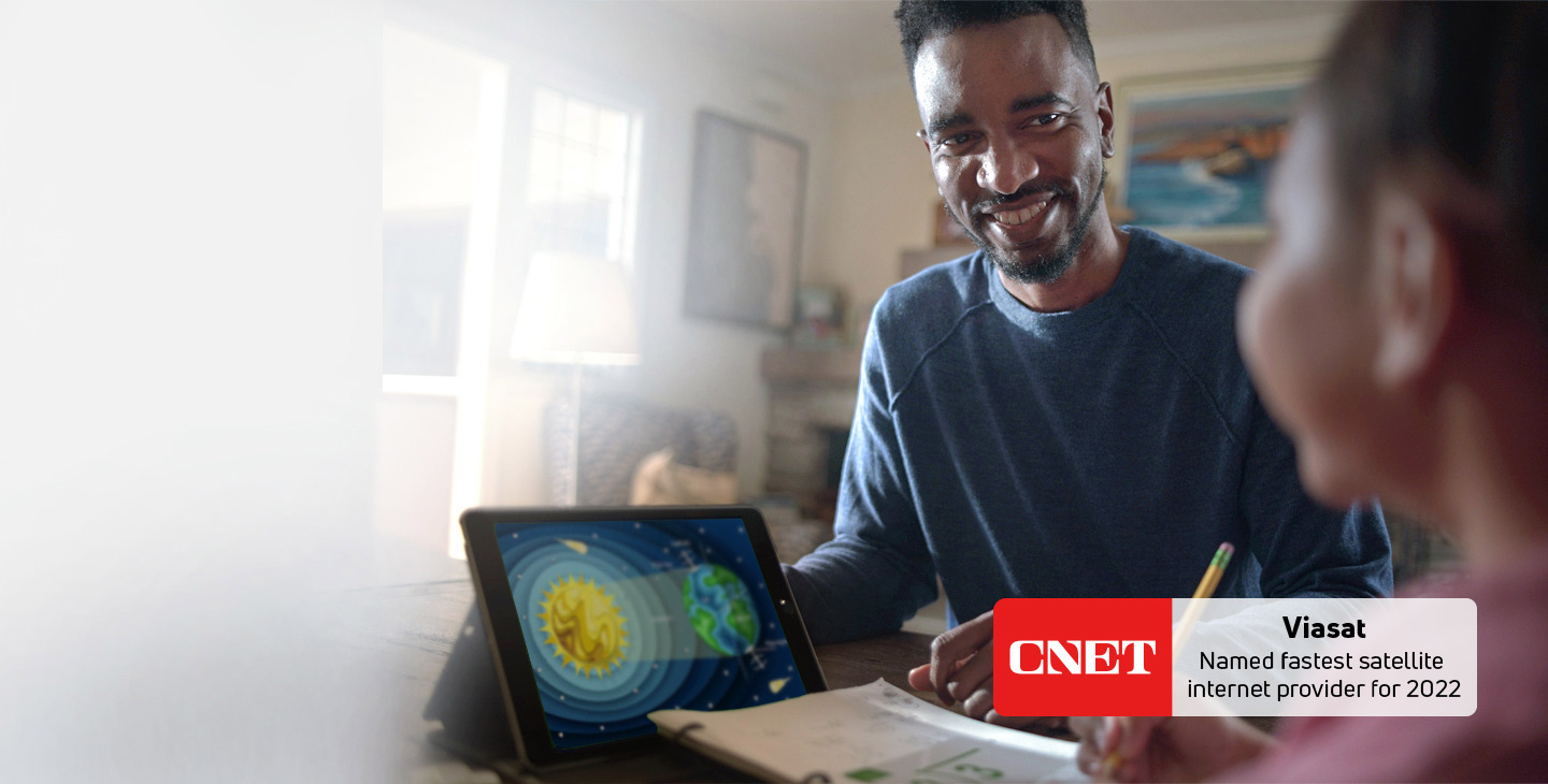 Father and child doing homework with tablet connected by Wi-Fi through Viasat's internet service
