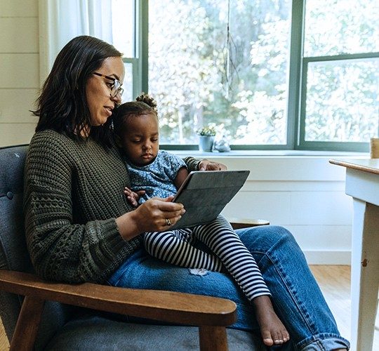 mom and daughter on laptop in rural home